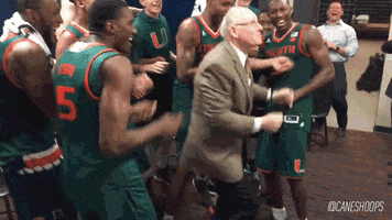 A coach dancing in the locker room as his players celebrate